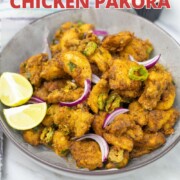 Chicken pakora in a bowl garnished with sliced onions.