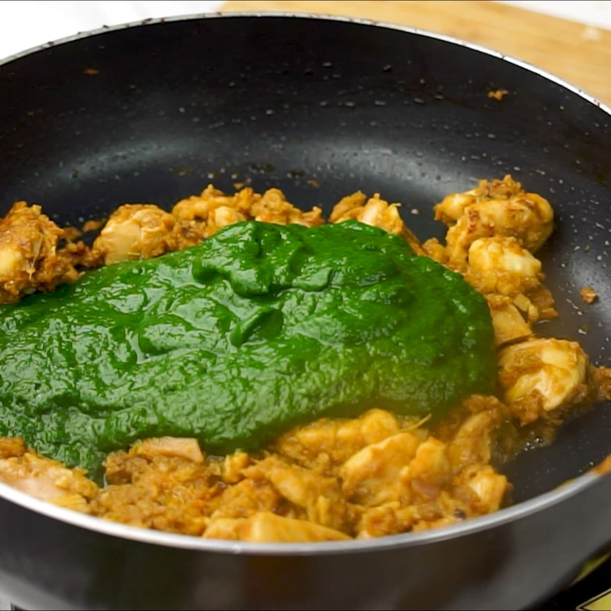 Add pureed spinach to sauteed chicken to make chicken saagwala