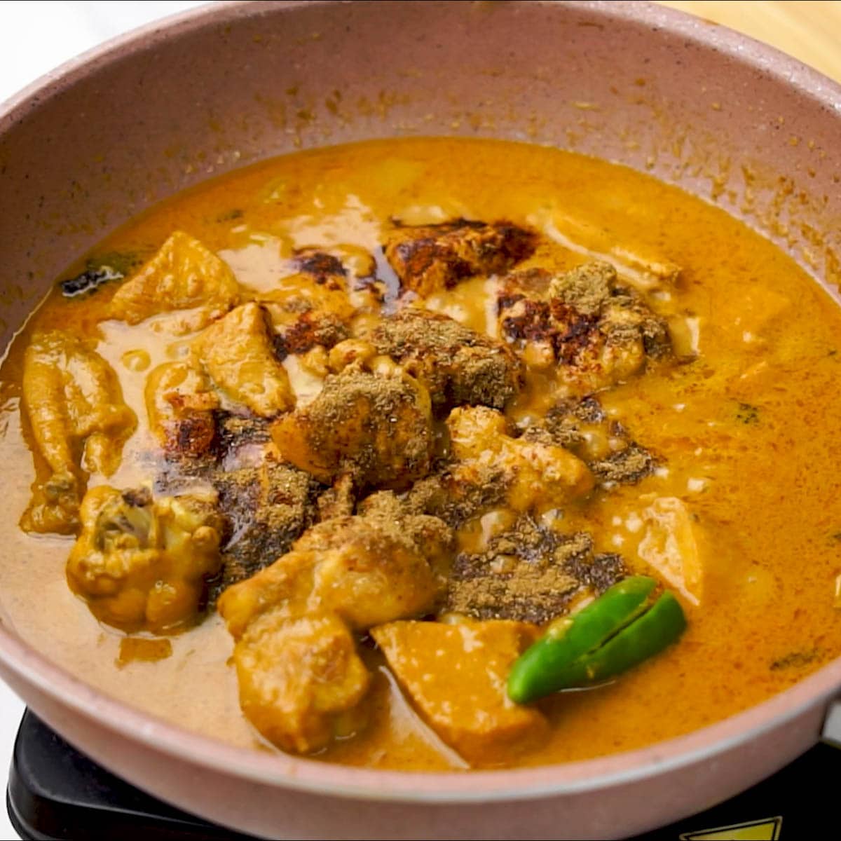 Adding Garam Masala to mughlai chicken zaafrani. 