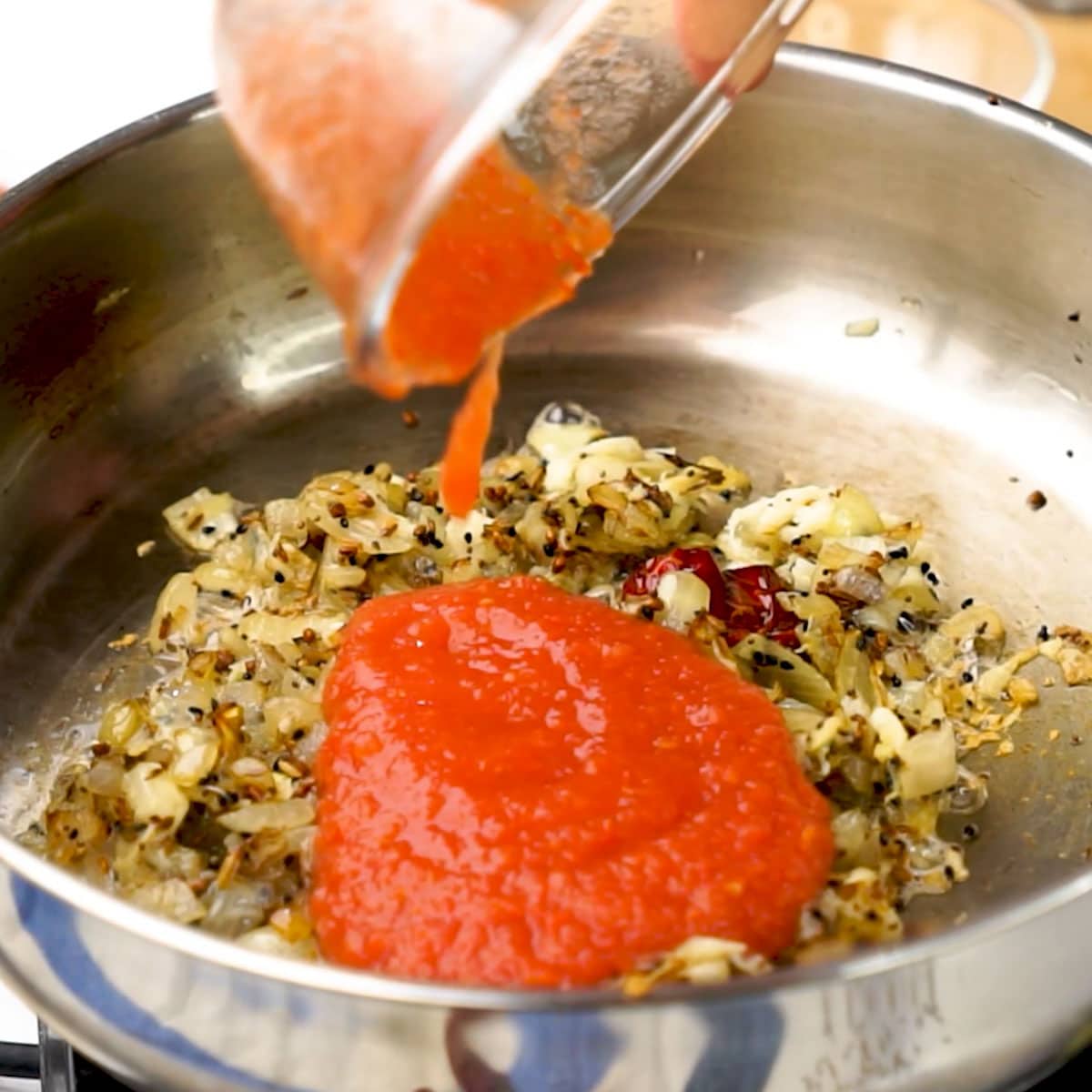 Adding Tomato Puree to the fry pan