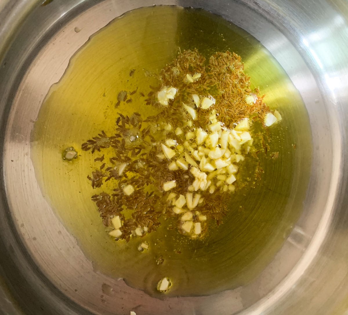Add cumin seeds, garlic to oil to make aloo methi