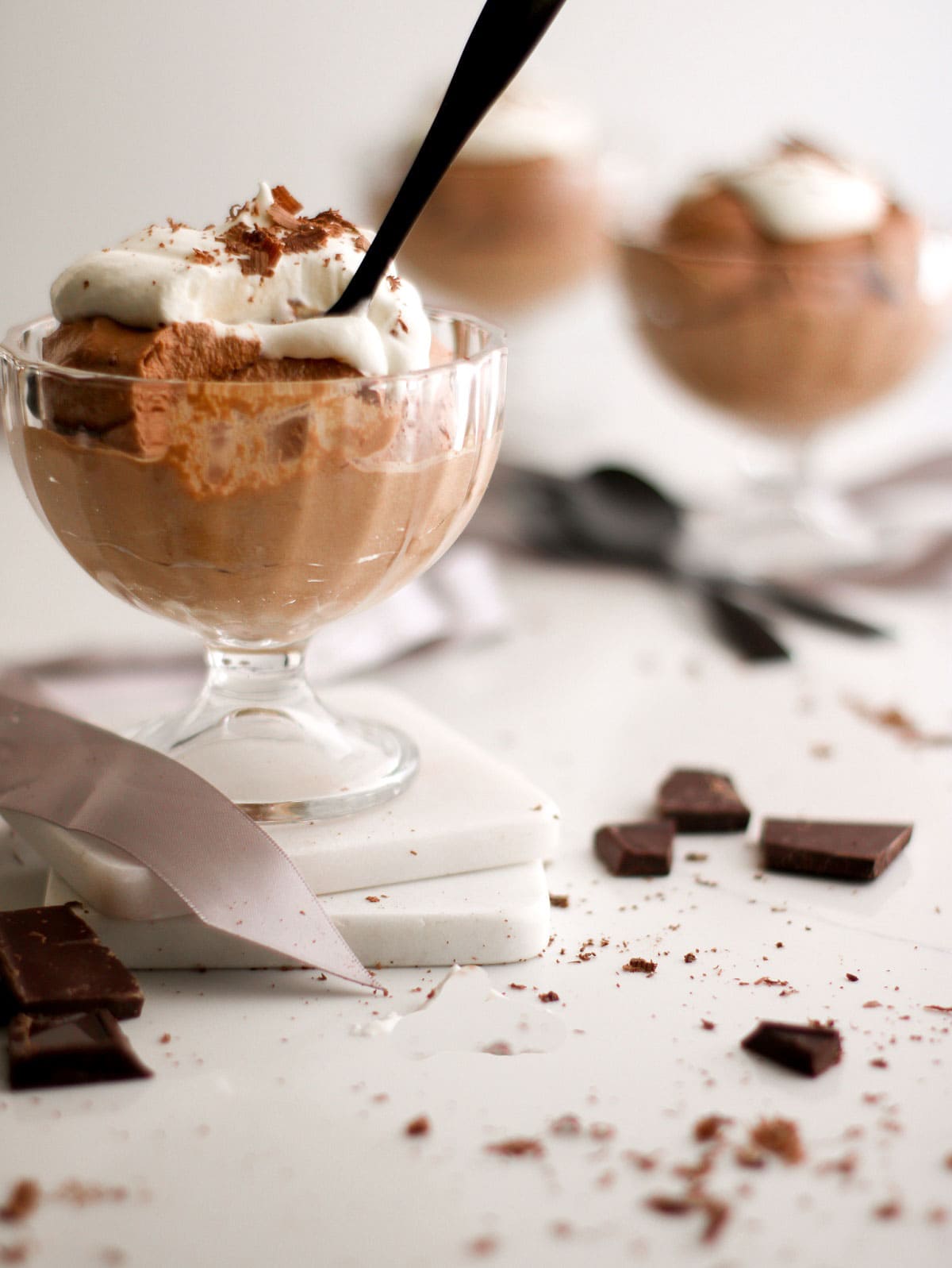 Homemade chocolate mousse in a glass serving dish with spoon.