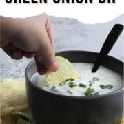 Green onion dip in a bowl with a chip being dipped in it.
