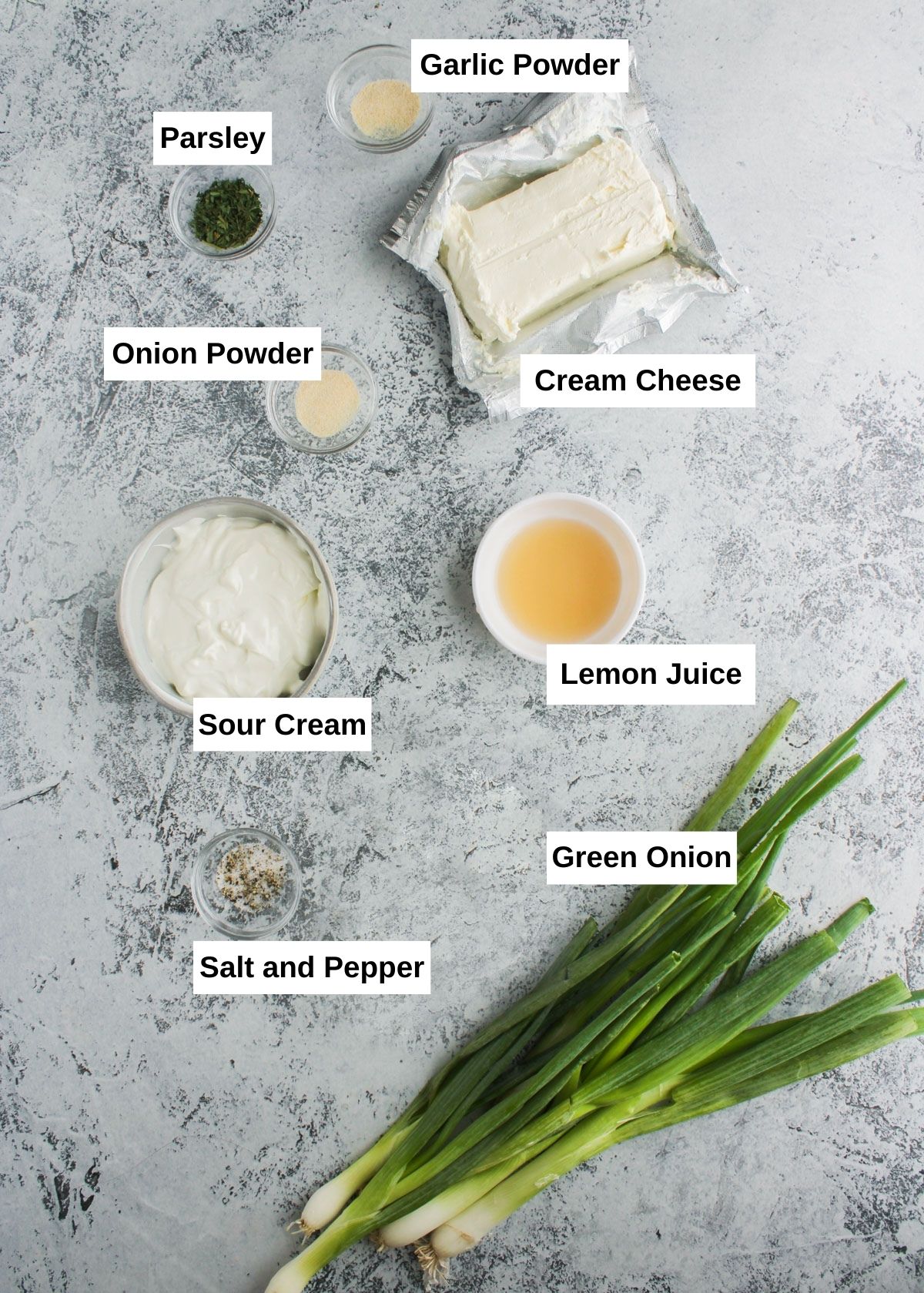 Green onion dip ingredients are ready on a gray table.