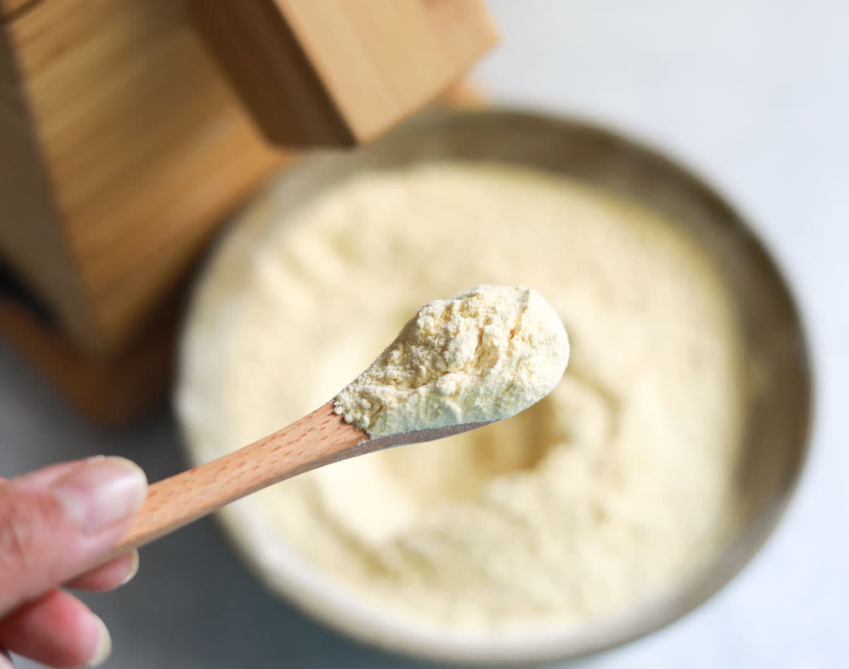 Finely ground chickpea flour in a spoon with Nutrimill in the back