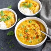 Bowls of red lentil curry with rice