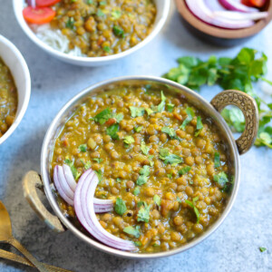 Masoor Dal made in instant pot served in a bowl along with onions, tomatoes