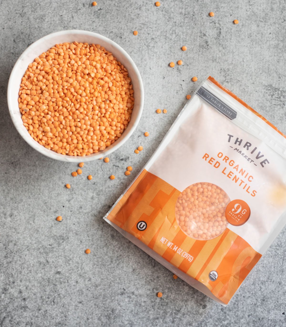 Red lentils in a white small bowl and packet