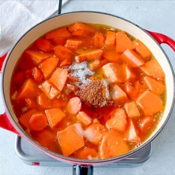 Adding the salt along with spices to the Pumpkin Carrot Soup