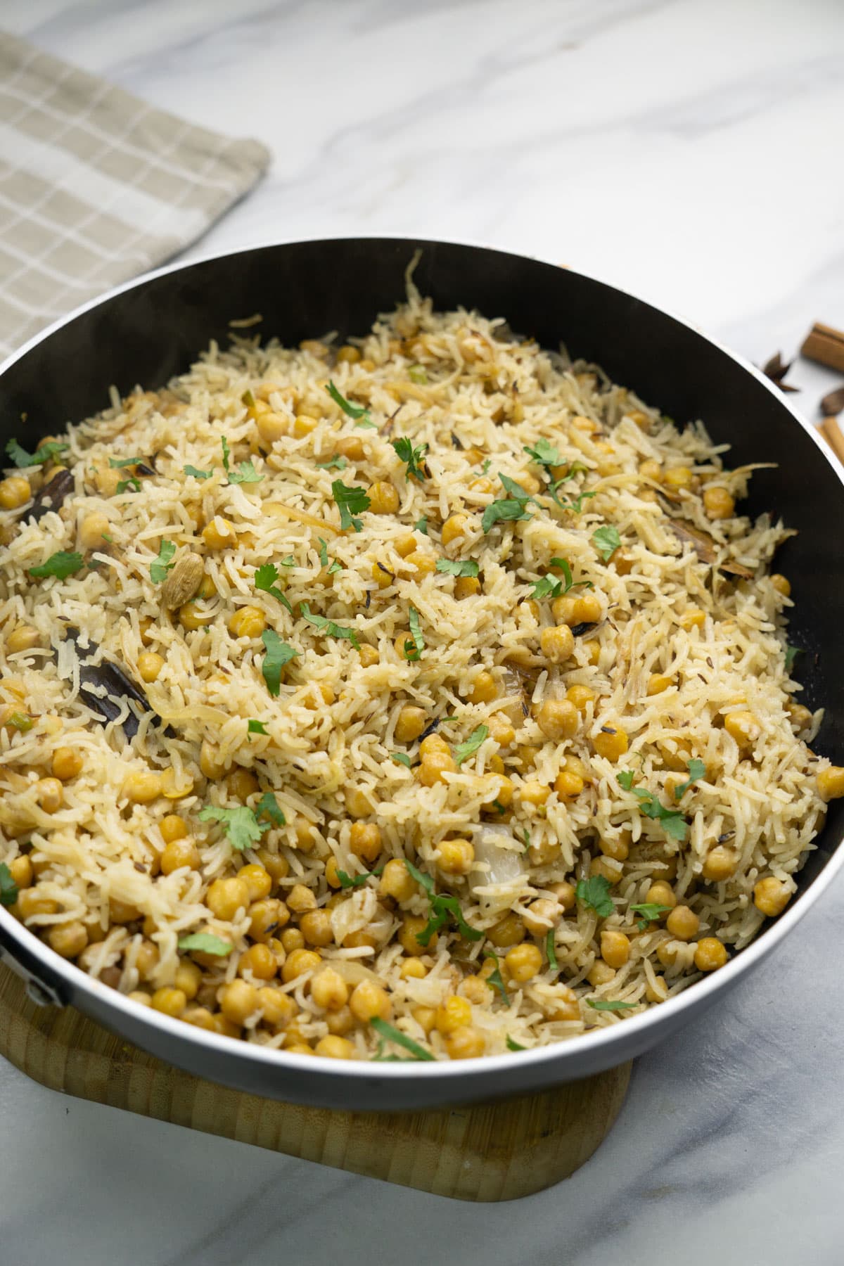 Chana Pulao garnished with cilantro leaves in a frying pan.