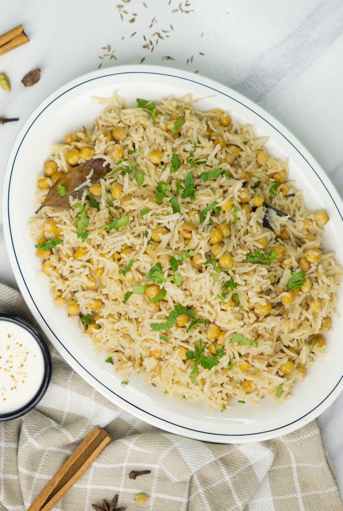 Chana Pulao with garnished with cilantro leaves and raita on the side.