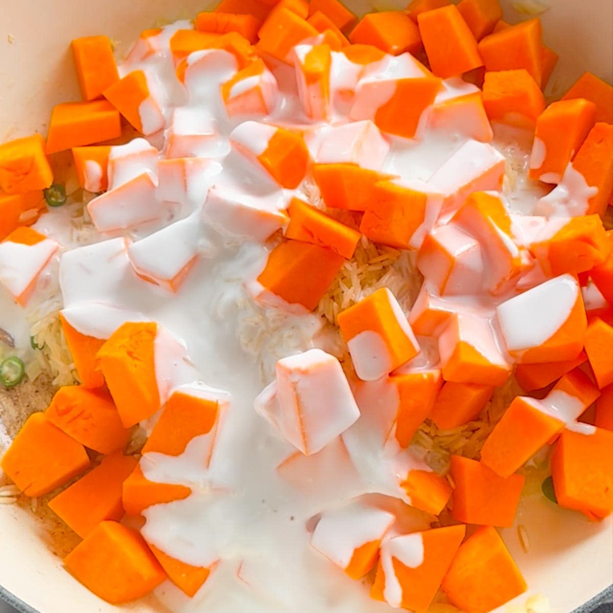 added coconut milk into the pan along with pumpkin and rice