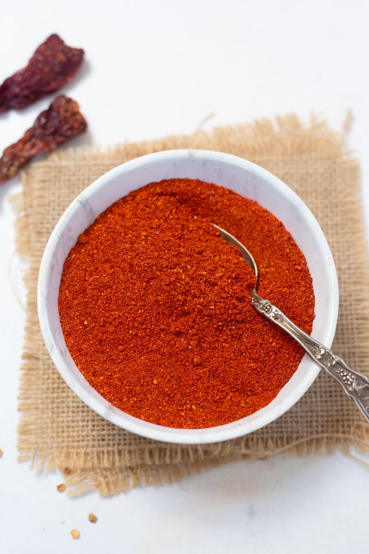 Homemade Indian Chili Powder in a white bowl with spoon