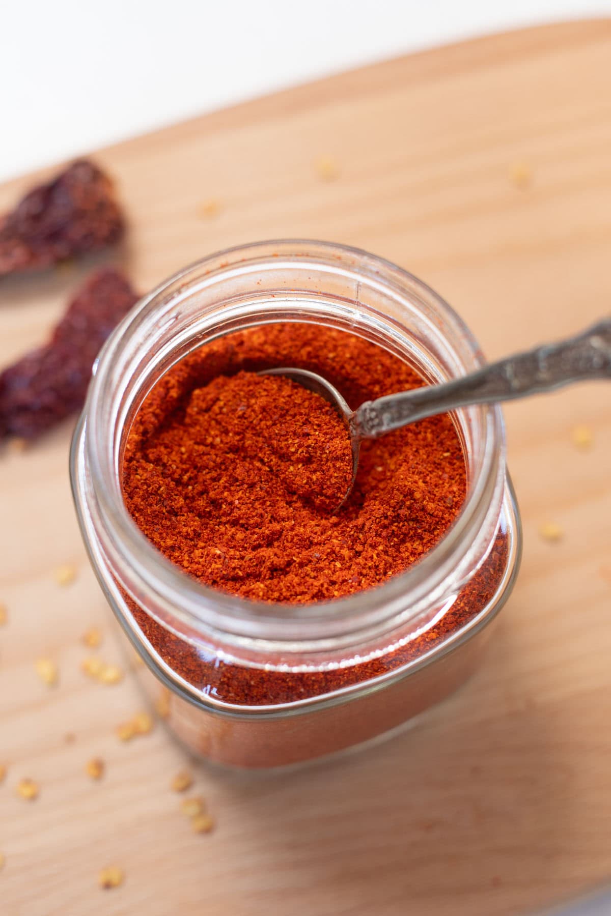 Indian red chili powder in a glass jar with spoon