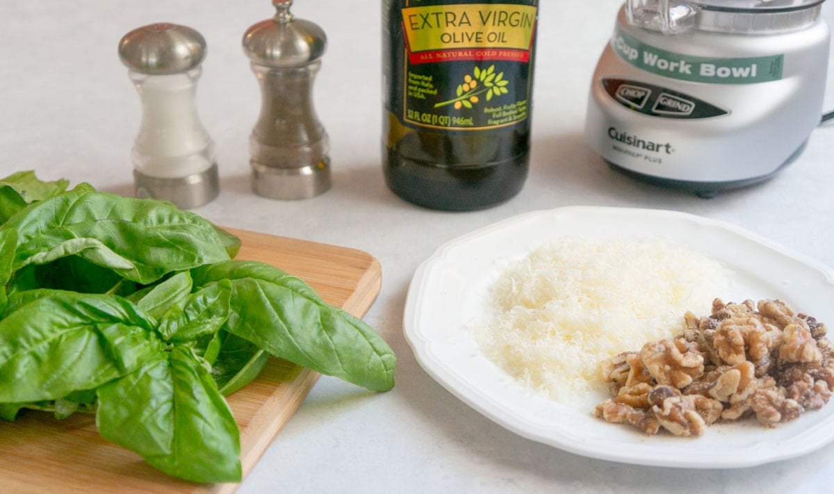 basil, cheese and nuts and other ingredients for Basil Walnut Pesto
