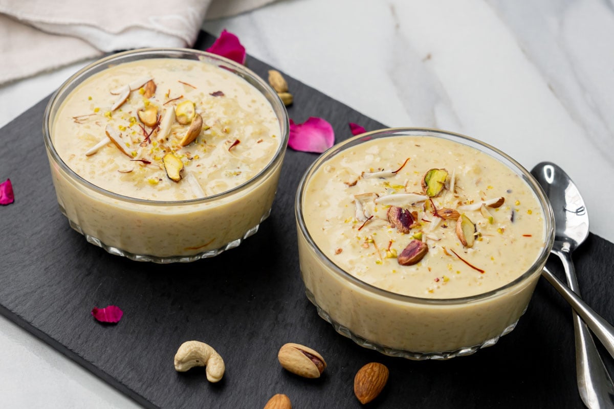 Indian Kheer served in two bowls garnished with nuts and saffron. 