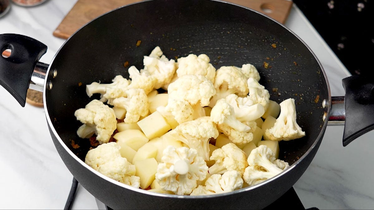 Add diced potatoes and cauliflower florets to the pan.