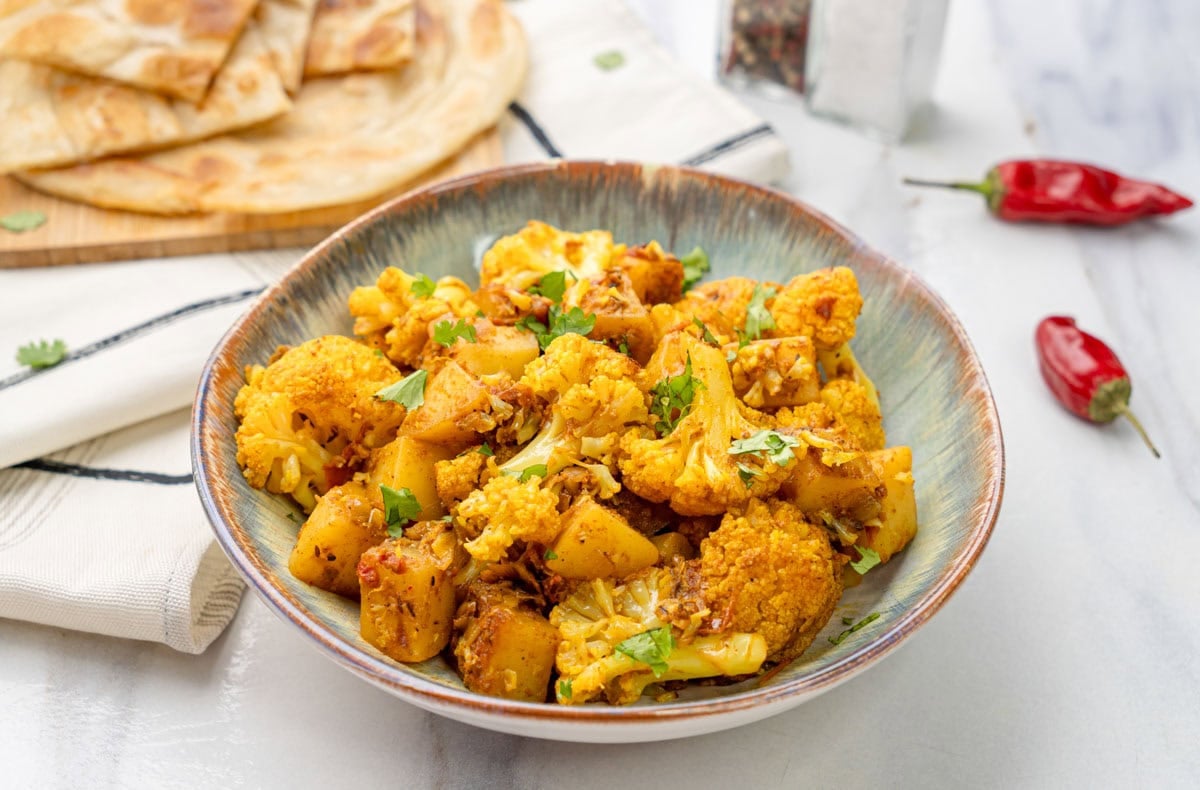 Aloo Gobi in a bowl with parotha on the side