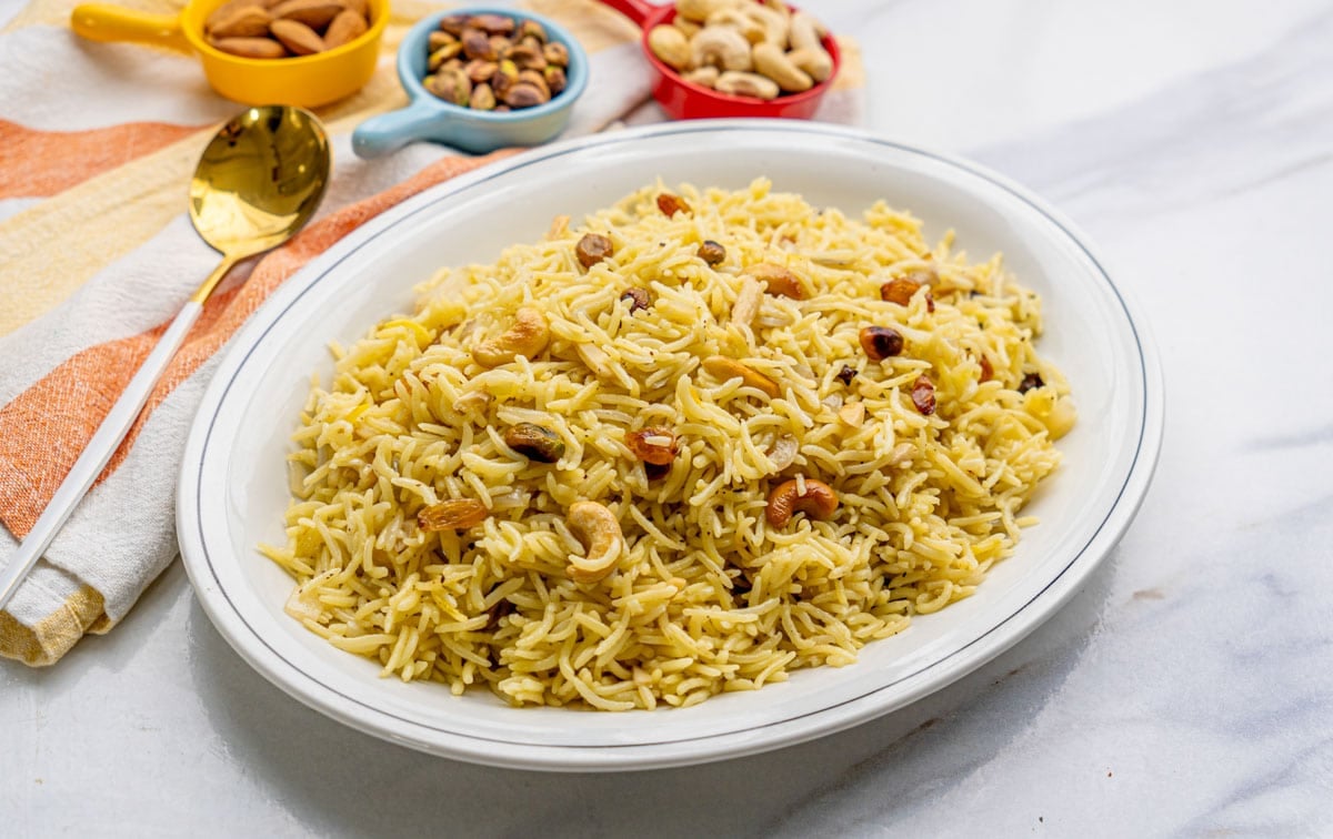 saffron rice with cashews in a white plate