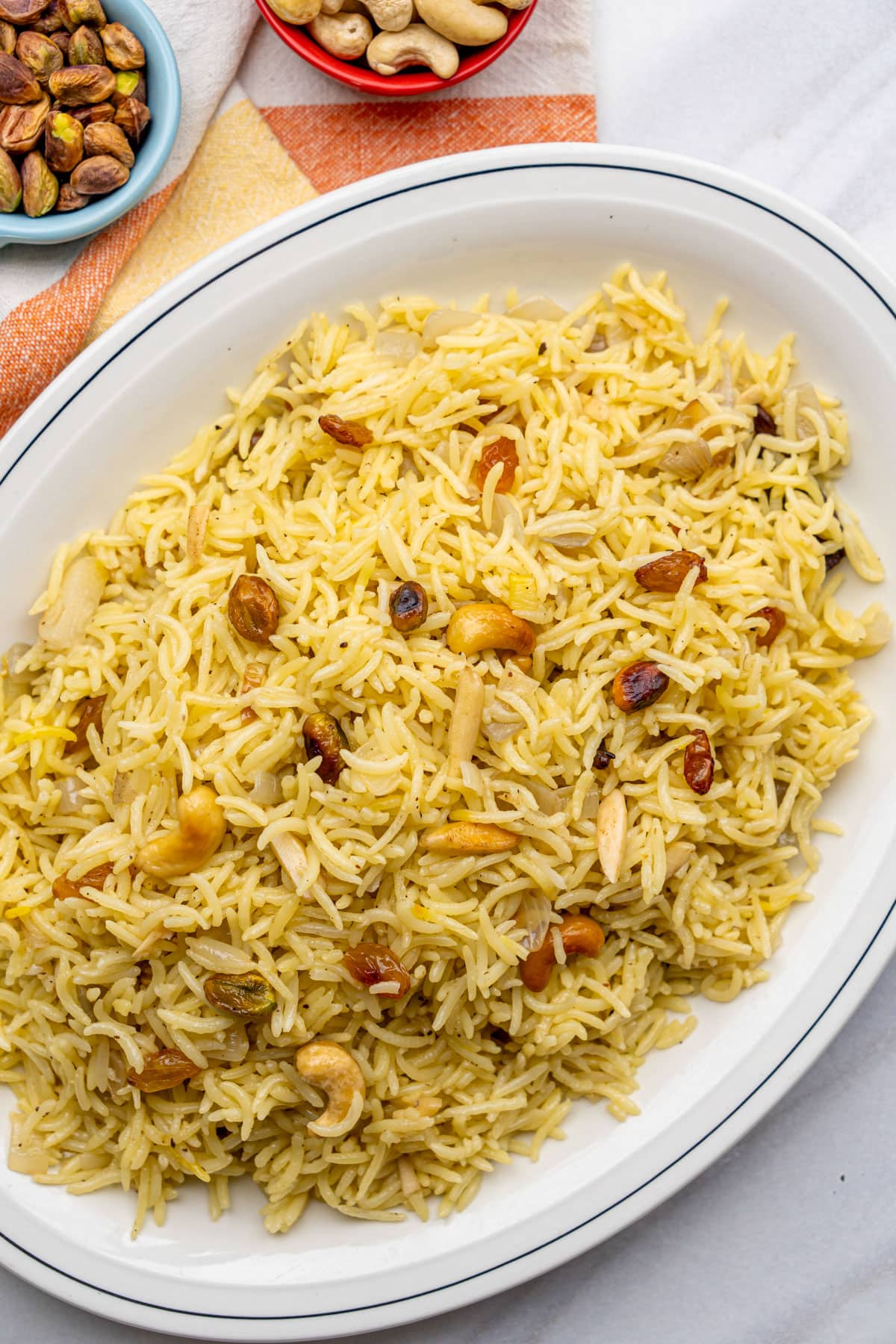 saffron rice with nuts and raising in a white serving plate