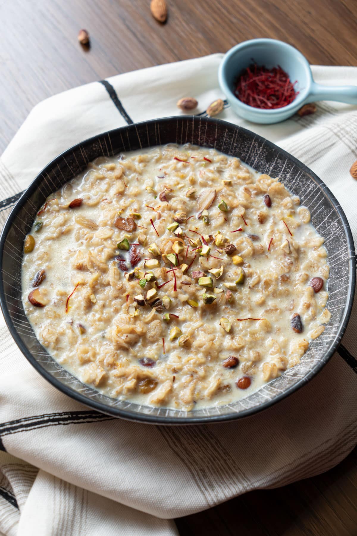 oats kheer in a bowl topped with pistachios and saffron