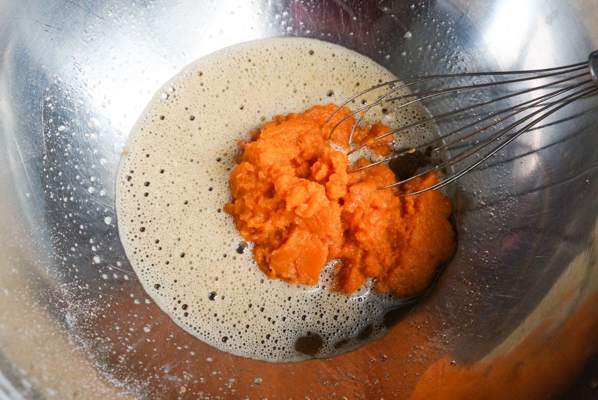 mixing wet ingredients for pumpkin oatmeal muffin in a bowl