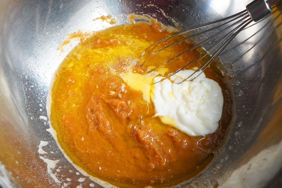 added vanilla and yogurt in a bowl with ingredients for pumpkin oatmeal muffin