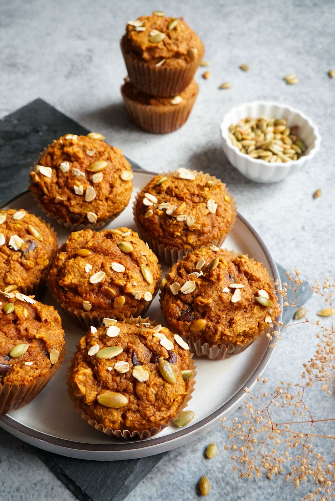 freshly baked Pumpkin Oatmeal Muffins topped with nuts in a serving plate