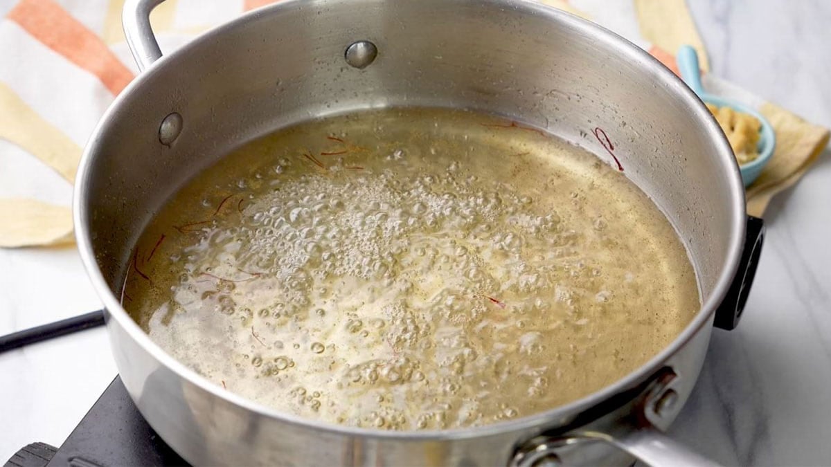 sugar syrup for gulab jamun in a stainless pan