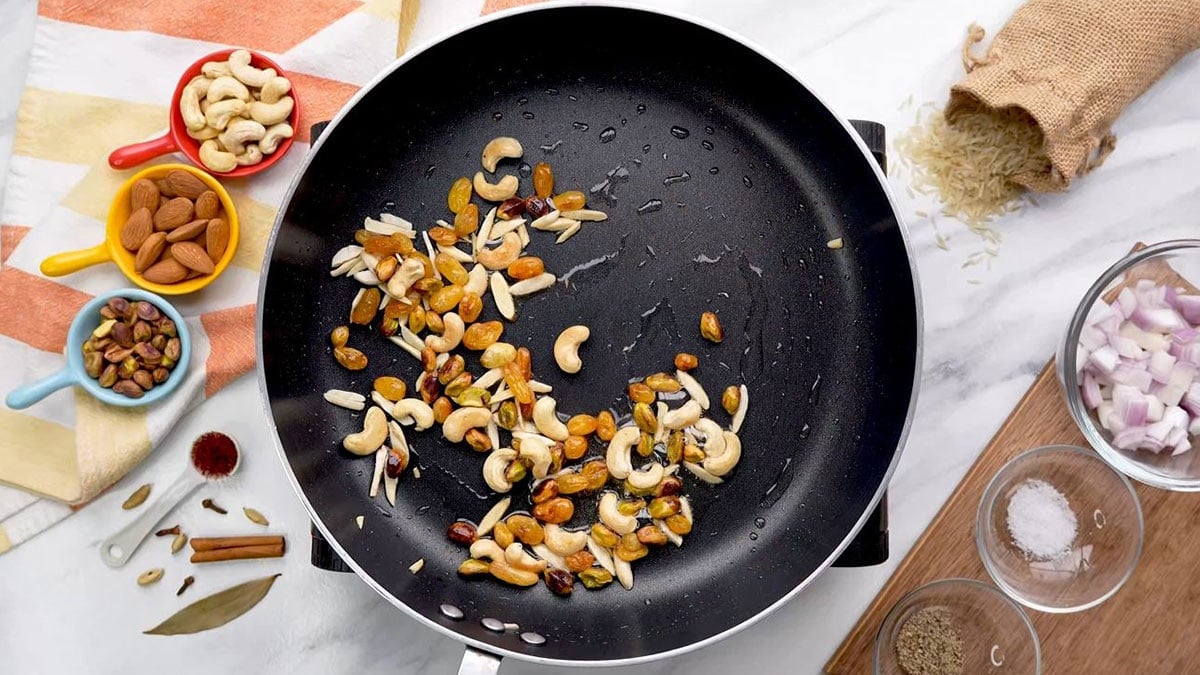 Sautéing mixed nuts in a pan