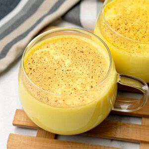 close up shot of haldi doodh in a cup topped with cinnamon powder