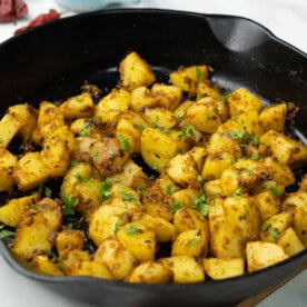 Jeera aloo in a pan garnished with cilantro