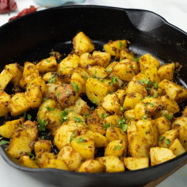 Jeera aloo in a pan garnished with cilantro