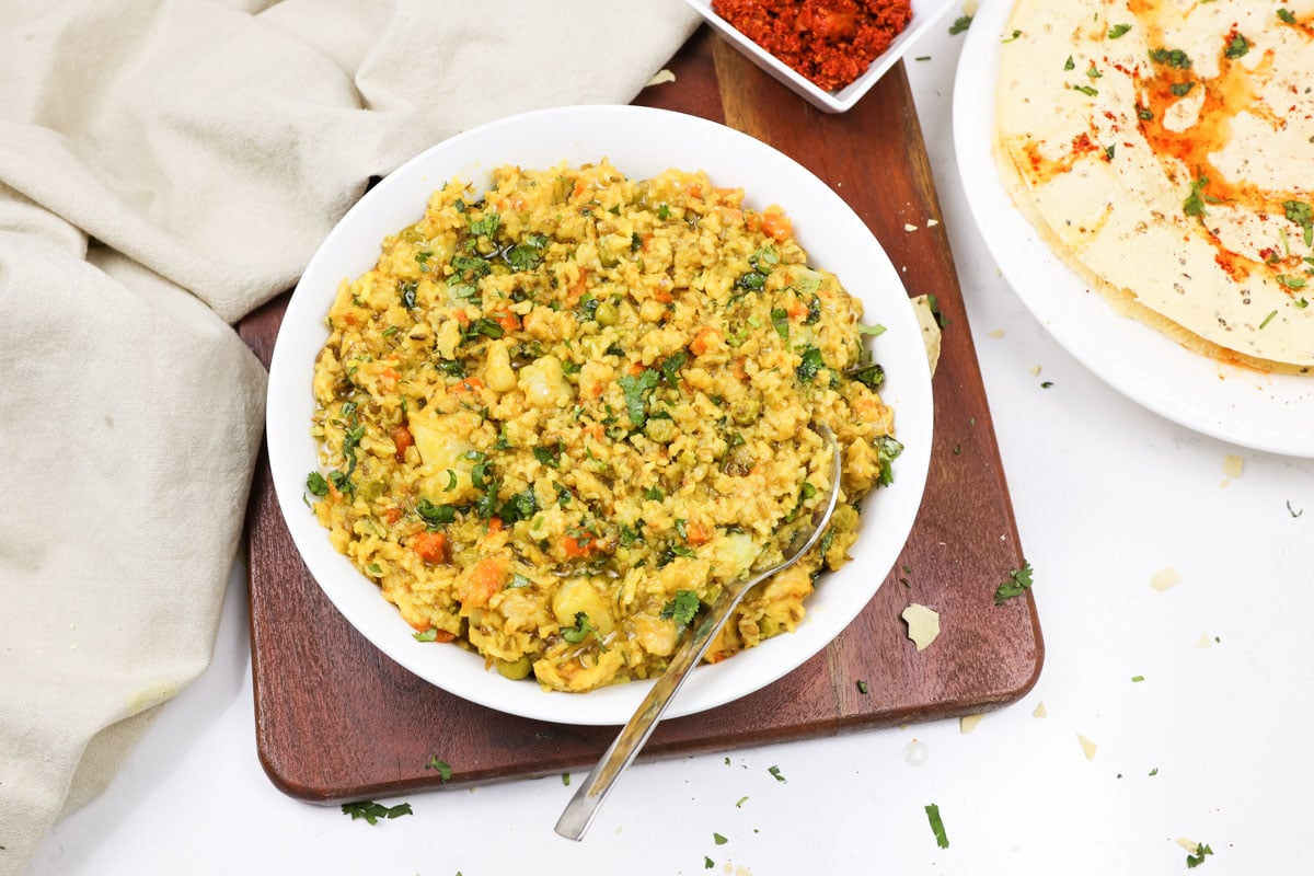 Masala Vegetable Khichdi in a white plate over the wooden board