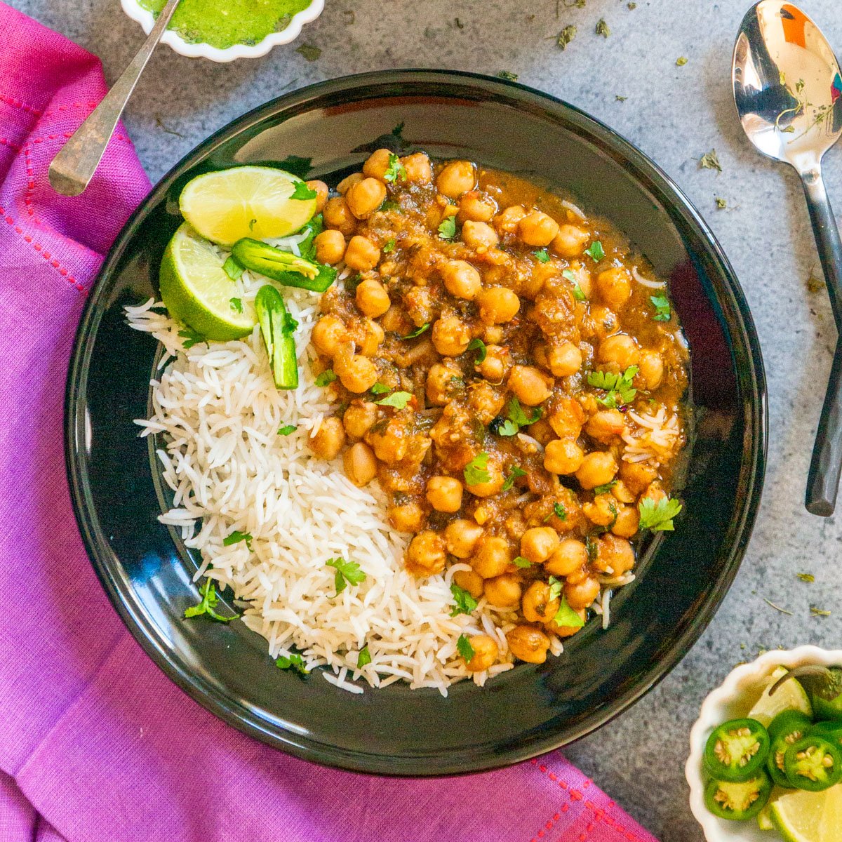 Chana Masala served along with basmati rice in a black bowl