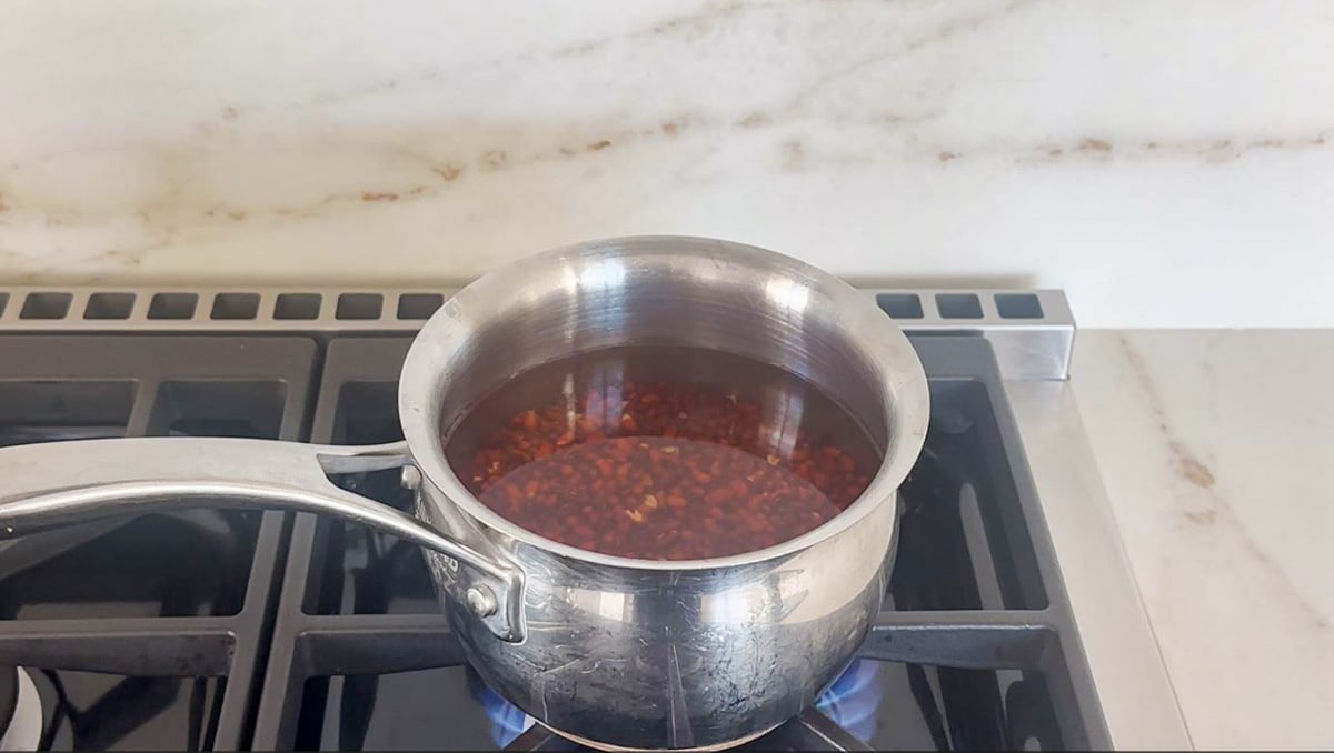 Adzuki beans and water in a pot on the stovetop. 