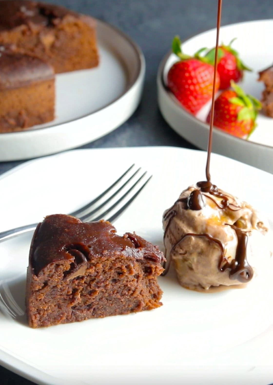 A piece of Instant Pot Brownie in a plate with ice-cream and chocolate sauce dripping