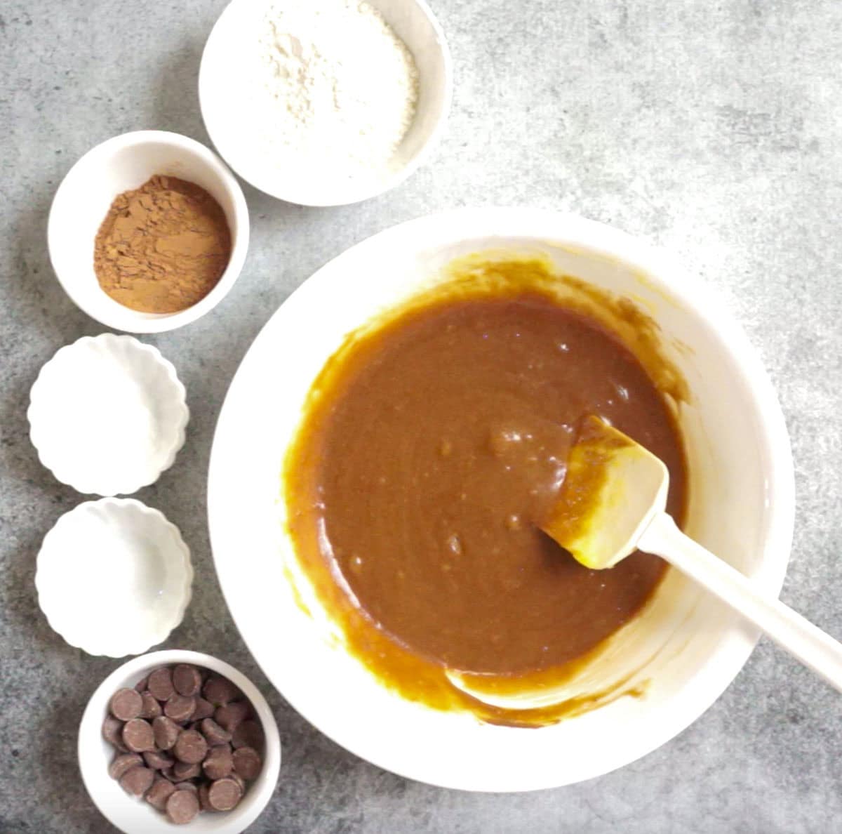 mixed melted butter and chocolate in a white bowl to make brownies