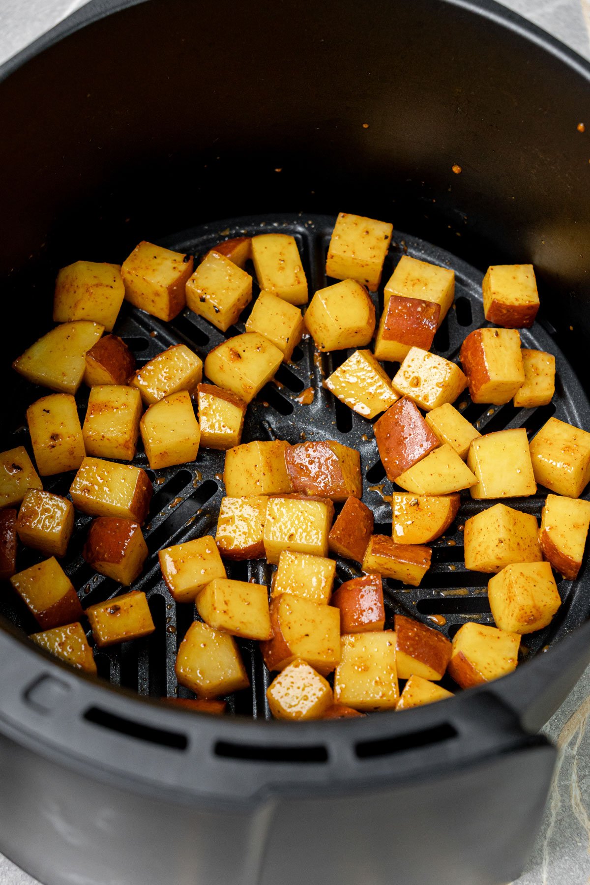 ready to air fry diced potato in an air fryer basket