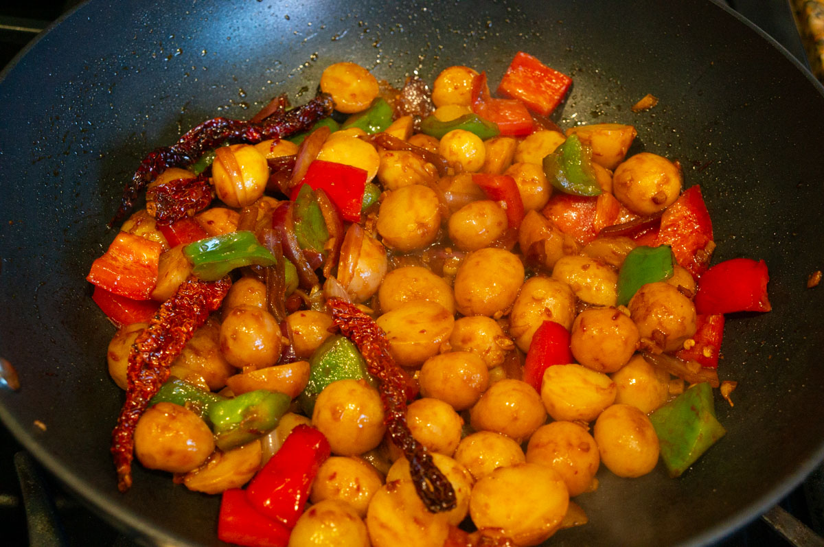 Cooked garlic chili potatoes on a black pan