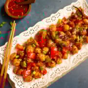 Closeup shot of garlic chili potatoes on a white serving plate