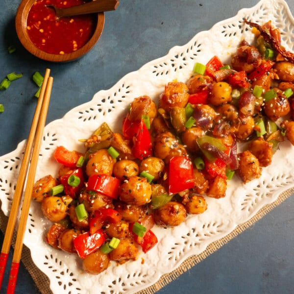Closeup shot of garlic chili potatoes on a white serving plate