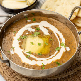 Dal makhani in a small bowl with butter, cream and cilantro