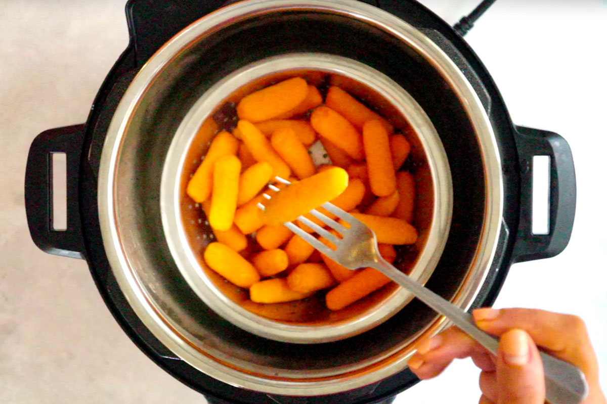Steamed carrots on a fork over the instant pot