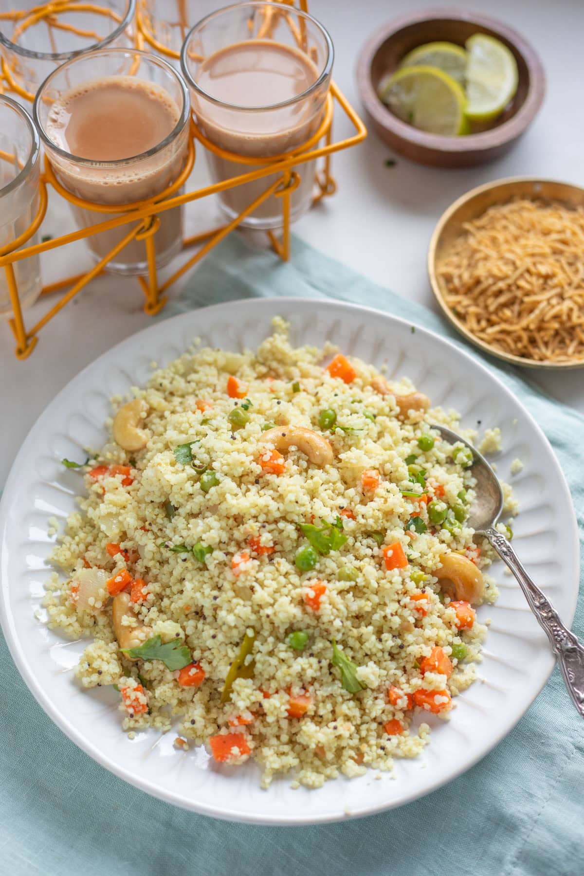 Millet upma with vegetables and cashews on a white plate