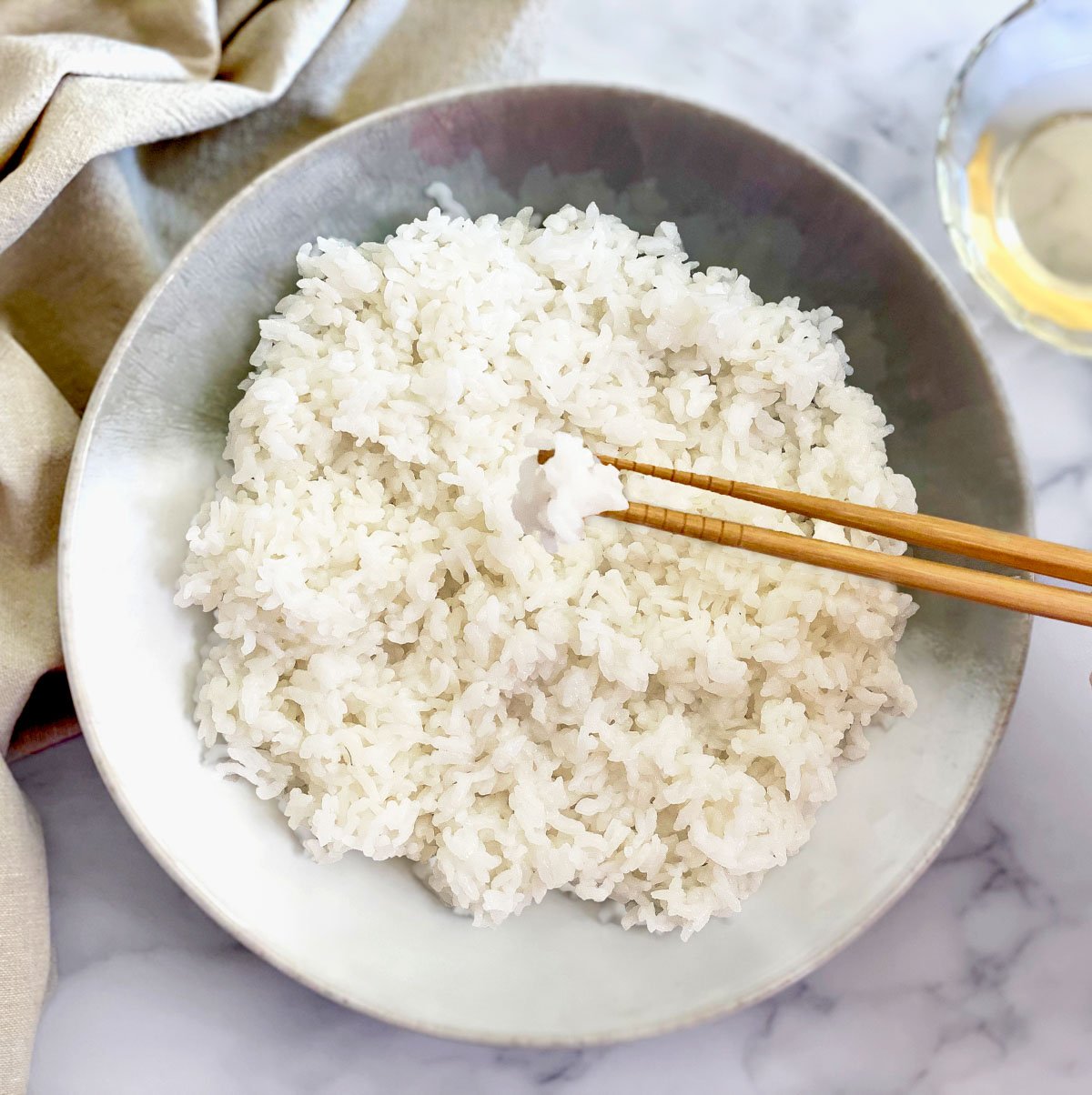 Sushi rice on a chopsticks over the the plate