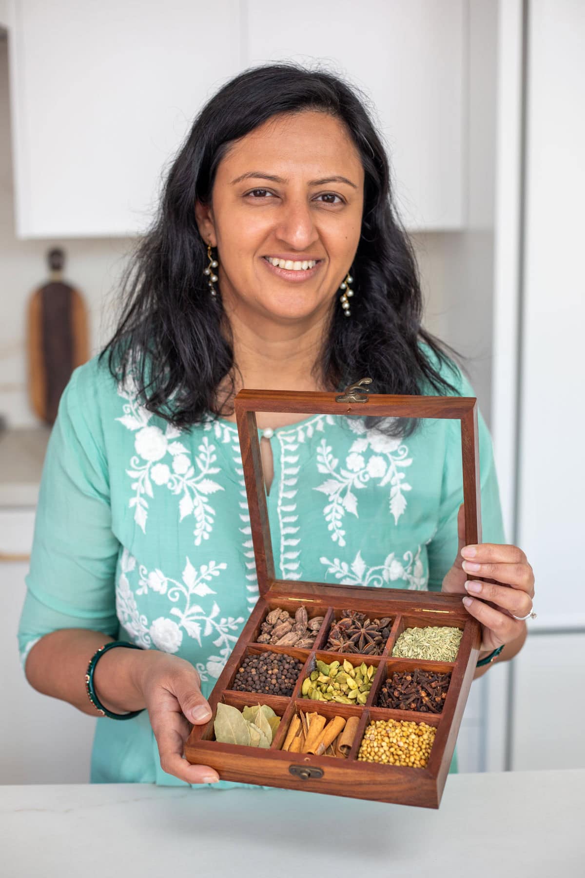 Meeta holding a wooden spice box
