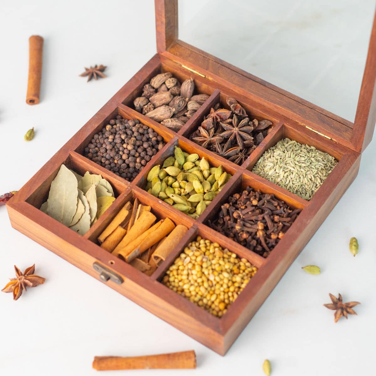 Wooden spice box filled with whole Indian spices