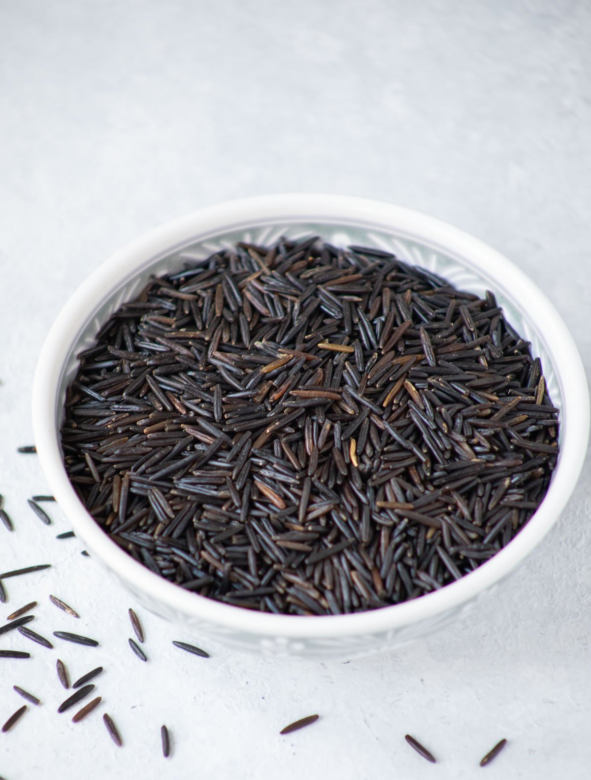 uncooked wild rice in a white bowl