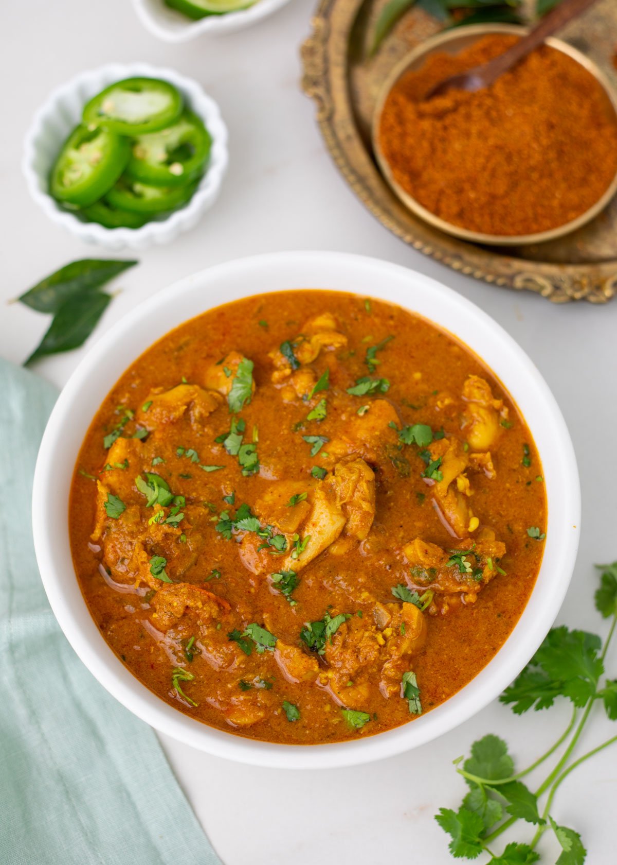 ready to serve Chicken chettinad garnished with cilantro in a white bowl